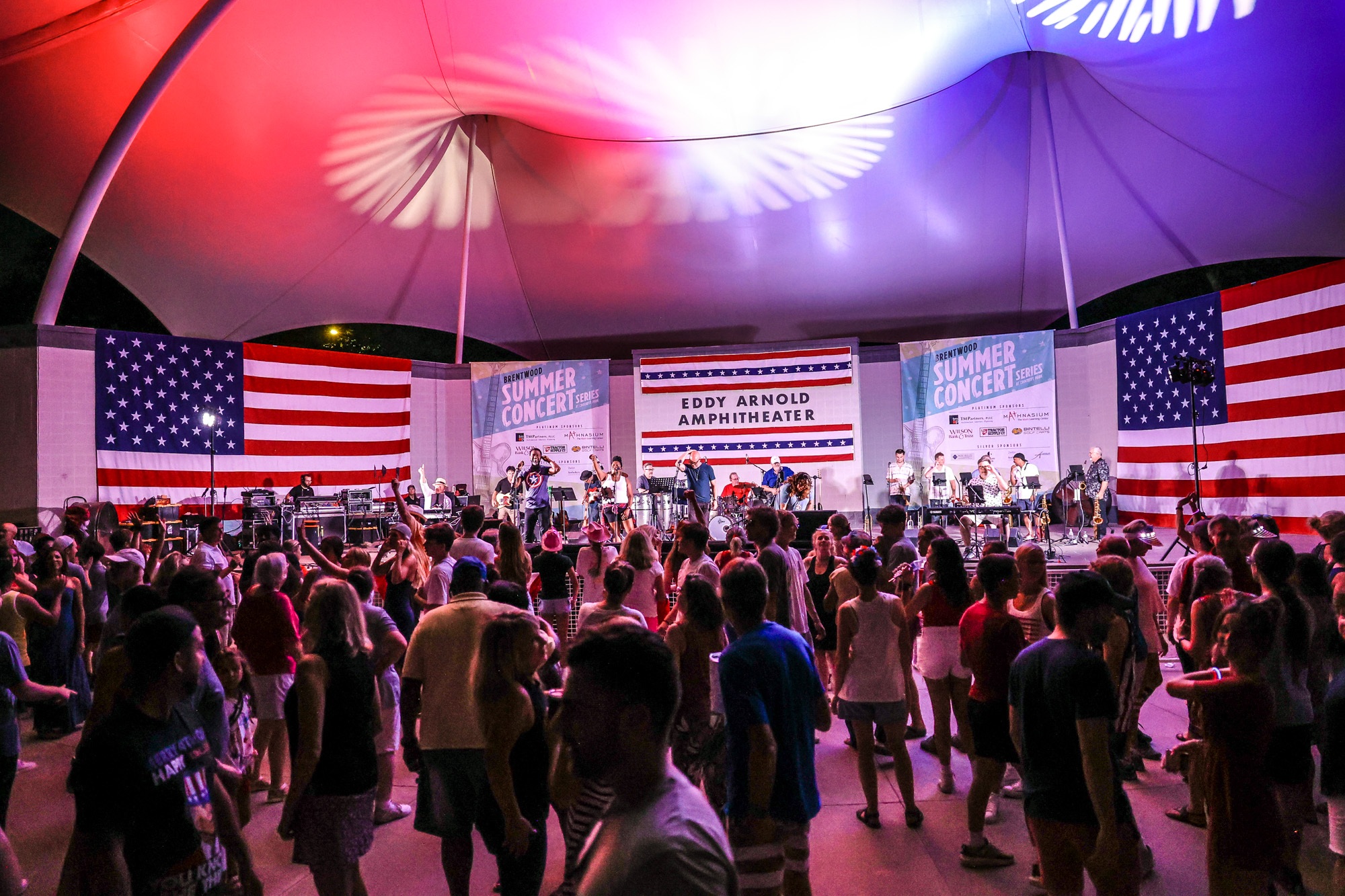 Fourth of July Concert, with people dancing in front of a band.