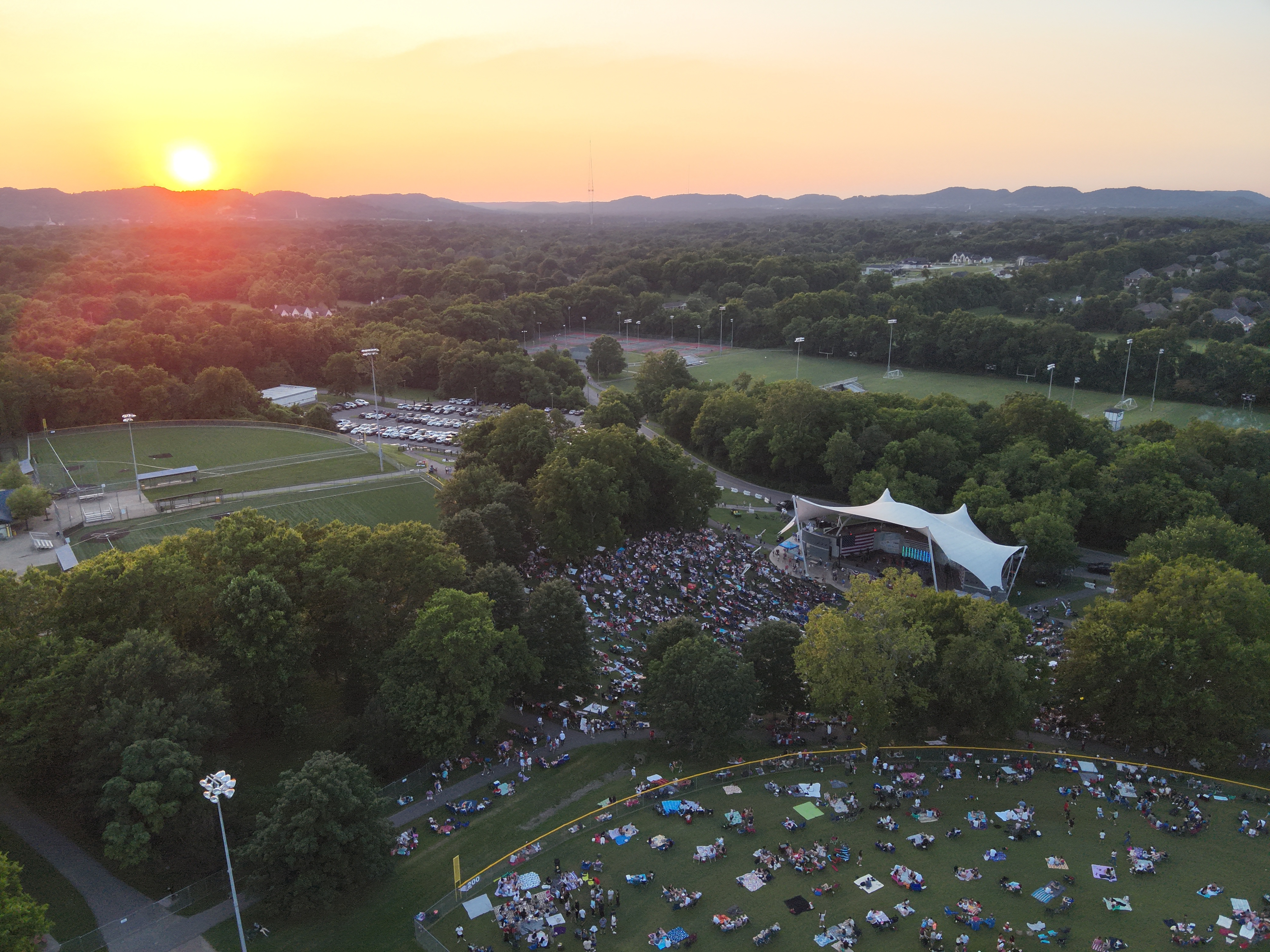 Aerial view of Crockett Park during a concert at sunset with thousands of people